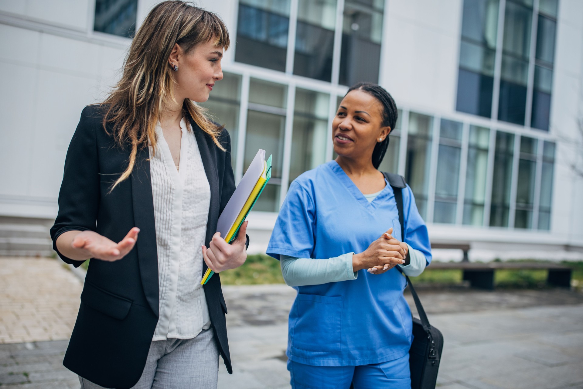 Nurse coming to new work and recruiter is welcoming her in front of the hospital
